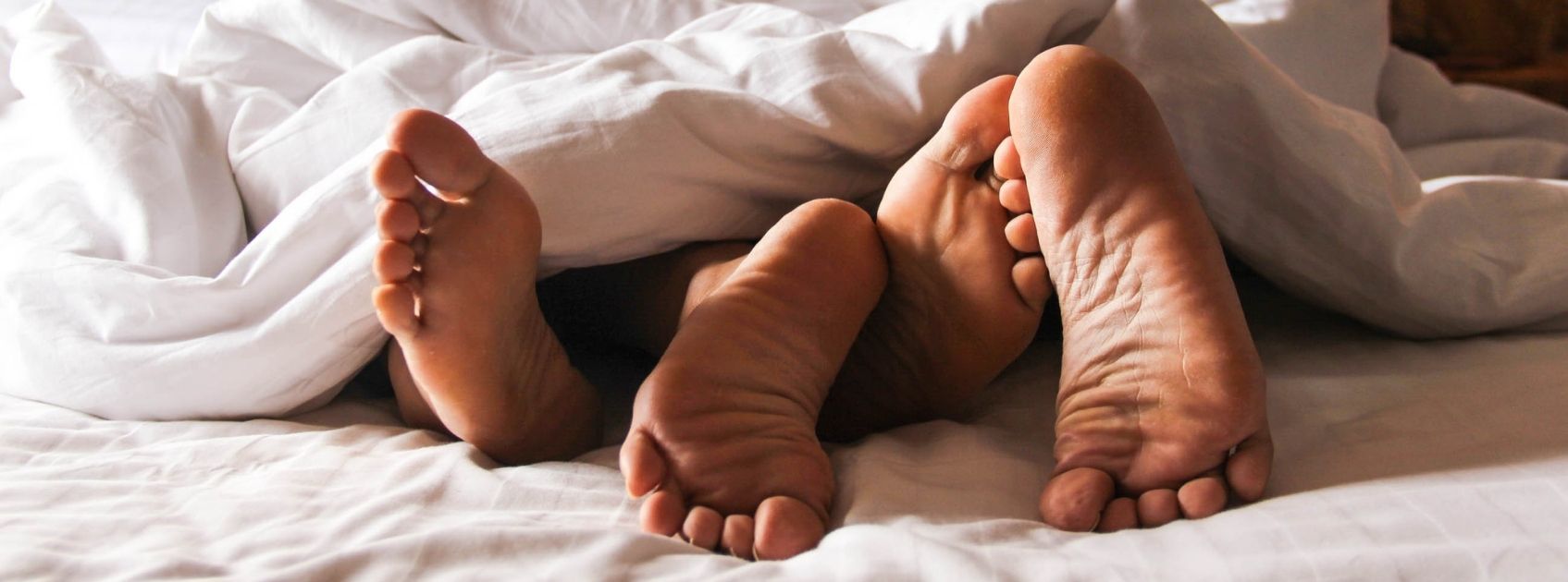 feet sticking out of bed covers