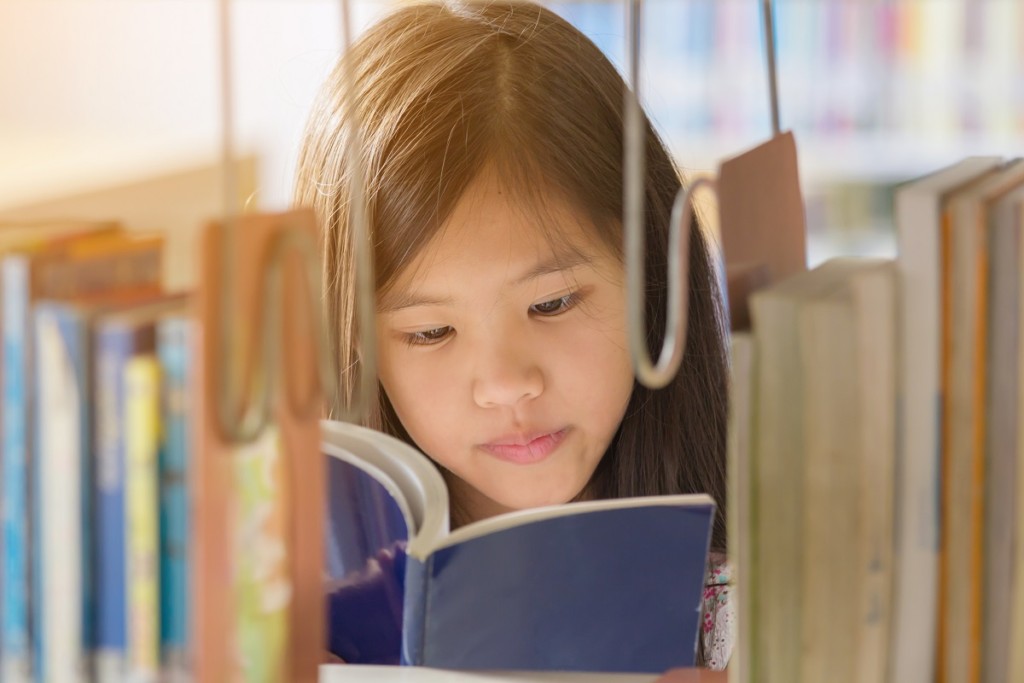 child reading in library in summer