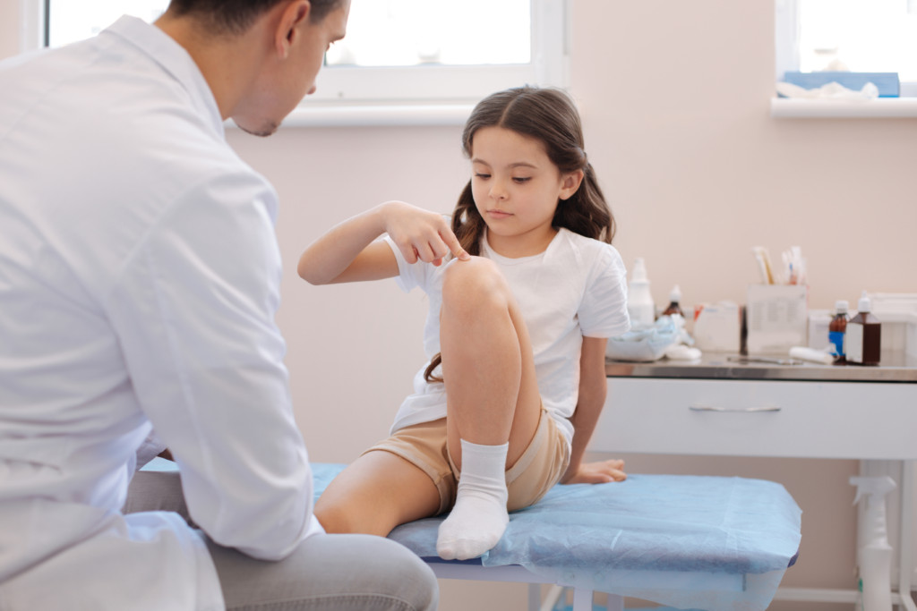 doctor looking at kids sports injury