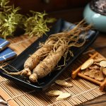 Ginseng,In,Black,Plate,On,Wooden,Table
