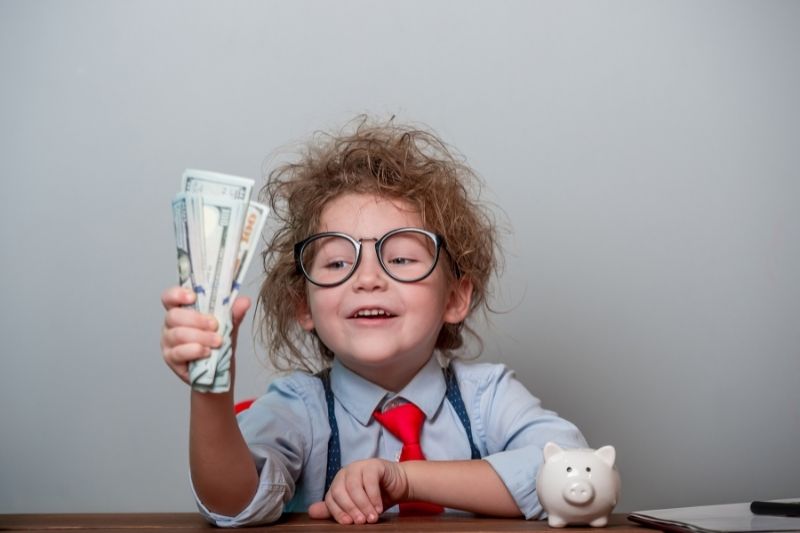 girl with glasses holding money