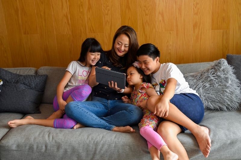 Mother on the Ipad with her three children enjoying some Screentime