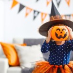 Shutterstock_Little girl holding pumpkin_Halloween costumes