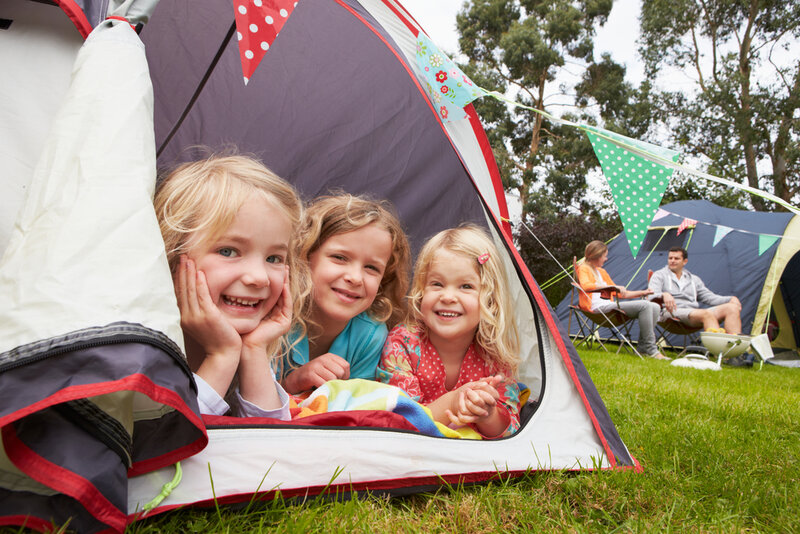 children camping outside in a tent