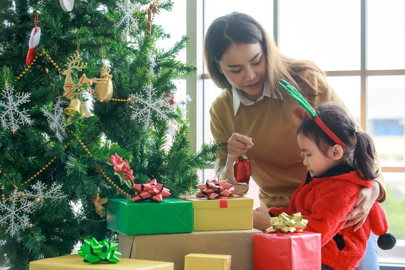 child giving a christmas gift to her mum