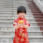 Little girl holding an orange during chinese new year