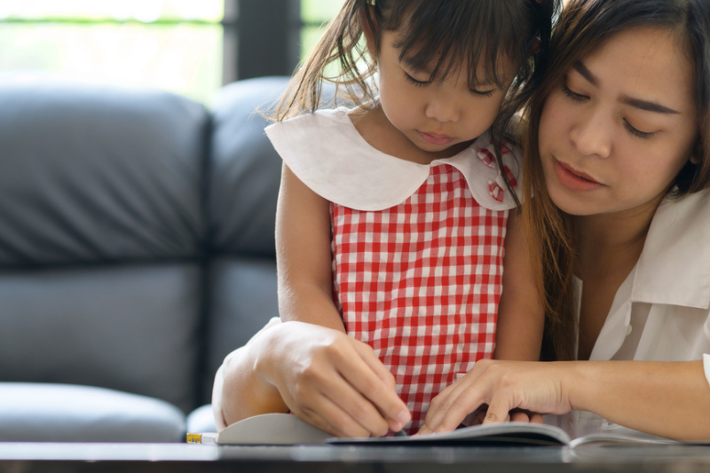 mum helping her child homeschooling