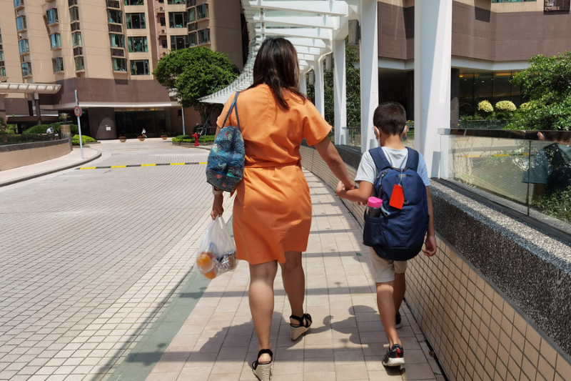 domestic helper walking a child to school