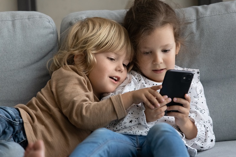 Two young children on a smartphone