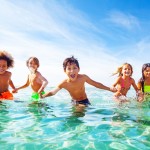 Kids,Laughing,And,Playing,In,Water,At,The,Seaside