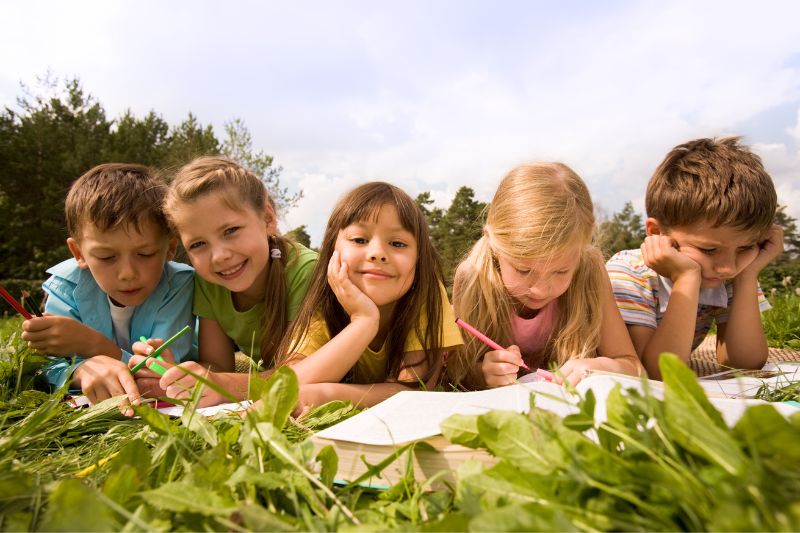 kids sitting in the grass reading
